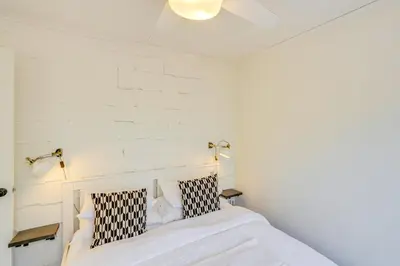 a white bedroom with a bed with two pillows at Mtn Views and On-Site Hiking Trails Catskills Cabin in Round Top