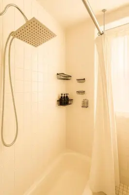 a bathroom with a tub and a shower with a shower curtain at 10 Min to NYC Quiet 1BR Flash Deal June 22 to 25 in Weehawken