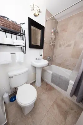 a bathroom with a toilet and a sink and a tub at Bright Studio in Central NYC in New York