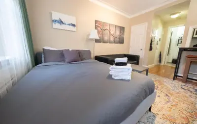 a bedroom with a bed with a stack of towels on it at Bright Studio in Central NYC in New York