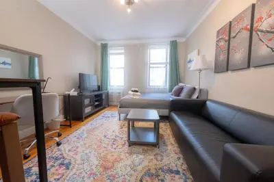a living room with a couch and a tv at Bright Studio in Central NYC in New York