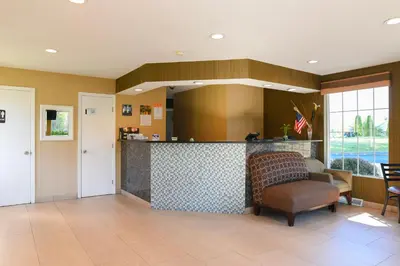 a lobby with a counter and a bar in a room at Capital Inn and Suites in Rensselaer