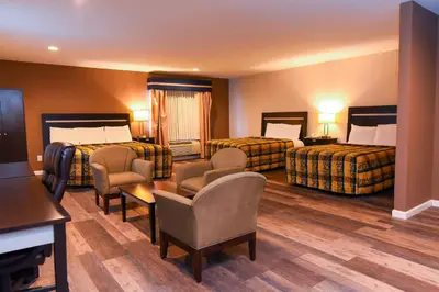 a hotel room with two beds and a table and chairs at Capital Inn and Suites in Rensselaer