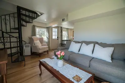 a living room with a couch and a table with flowers on it at Hadley Hideaway Cottage in Hadley