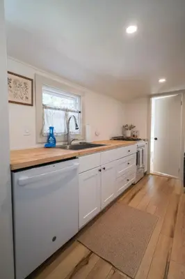 a kitchen with white cabinets and a sink and a window at Hadley Hideaway Cottage in Hadley