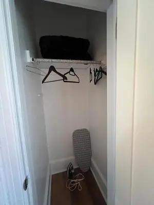 a closet with glasses on a shelf and a chair at Waterfront NYC skyline views in Union City