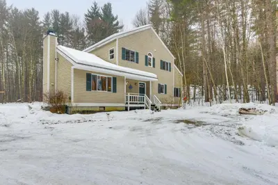 a house in the snow in the woods at 7 Mi to Mt Snow Resort Family Home with Fire Pit! in Dover