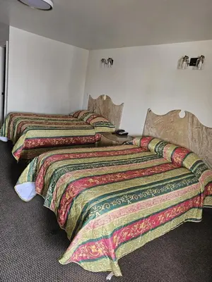 two beds sitting next to each other in a bedroom at Westview Motel in North Bergen