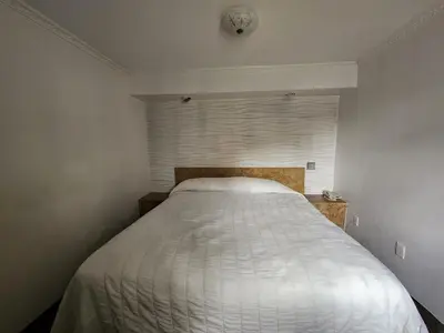 a white bed in a room with a window at Westview Motel in North Bergen