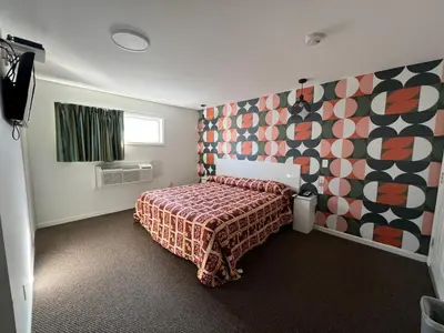 a bedroom with a bed with a patterned bedspread at Winslow Motel in Lyndhurst