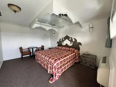 a bedroom with a large bed and a table at Winslow Motel in Lyndhurst