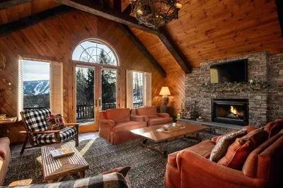 a living room with couches and a fireplace at Black Bear Cabin in Windham