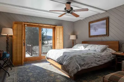 a bedroom with a bed and a ceiling fan at Black Bear Cabin in Windham