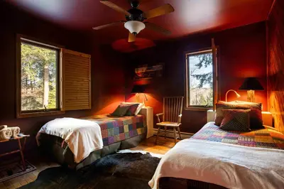 a bedroom with two beds and a ceiling fan at Black Bear Cabin in Windham