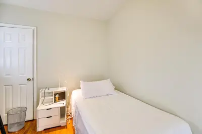 a white bedroom with a bed and a microwave at 3 Mi to Downtown Spacious White Plains Home in White Plains