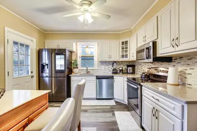 a kitchen with white cabinets and a stainless steel refrigerator at 3 Mi to Downtown Spacious White Plains Home in White Plains