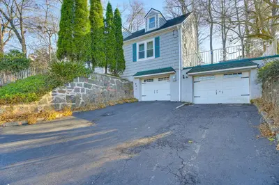 a house with two garage doors and a driveway at 3 Mi to Downtown Spacious White Plains Home in White Plains