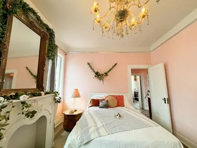 a bedroom with a bed and a mirror and a chandelier at NYC views Spacious 3 bedroom apartment in Union City