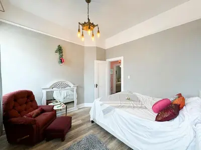 a bedroom with a bed and a chair at NYC views Spacious 3 bedroom apartment in Union City