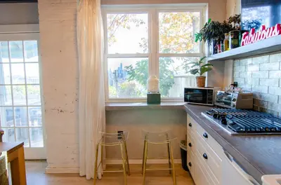 a kitchen with two stools and a stove and a window at Amazing views of NYC and Patio 10 mins from NYC in Union City