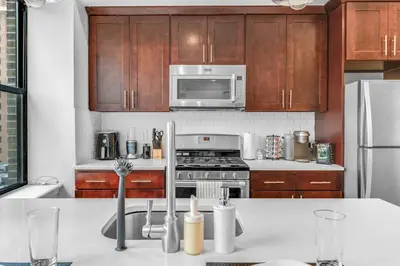 a kitchen with a stove and a microwave at 20 MIN to Manhattan! 2BR Luxurious Comfy & Spotless in Newark