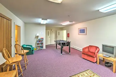 a room with chairs and a table and a television at Snow Mountain Condo Hot Tub and Shuttle to Resort in West Dover