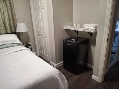 a bedroom with a bed and a table with a lamp at Two-Bedroom Home Private Parking 25 min to NYC in Teaneck