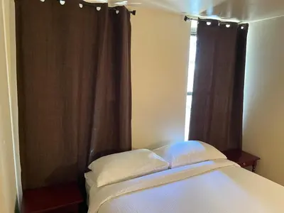 a bedroom with a bed and a window with curtains at One Bedroom by Month Next to Bronx Zoo in West Farms