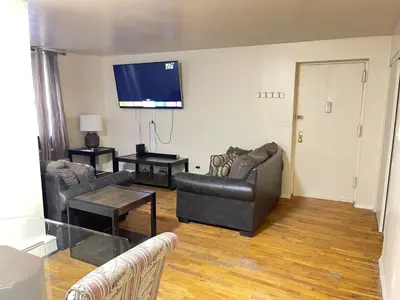 a living room with two couches and a flat screen tv at One Bedroom by Month Next to Bronx Zoo in West Farms