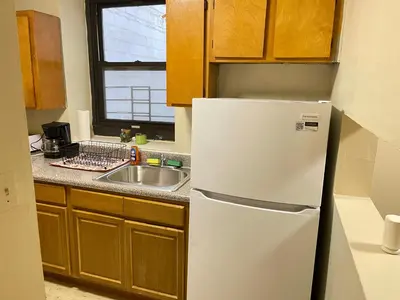 a white refrigerator in a kitchen with a sink at One Bedroom by Month Next to Bronx Zoo in West Farms