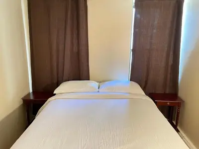 a bed with two pillows and a window in a room at One Bedroom by Month Next to Bronx Zoo in West Farms