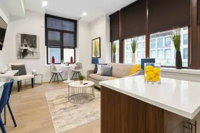 a kitchen and living room with a couch and a table at Charming 1BR King Bed - Just 20 Minutes from NYC! in Newark