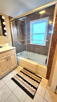 a bathroom with a bath tub and a window at Friendly Home Near NYC in Little Ferry