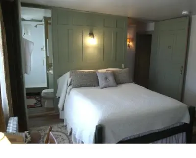 a bedroom with a white bed and a bathroom at The Old Inn On The Green in New Marlborough