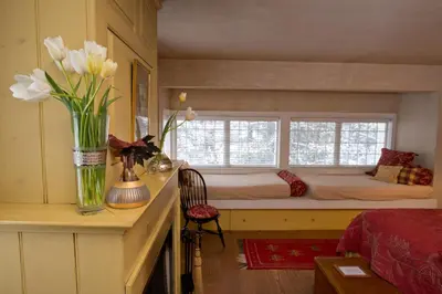 a bedroom with a bed and a vase of flowers on a counter at The Old Inn On The Green in New Marlborough