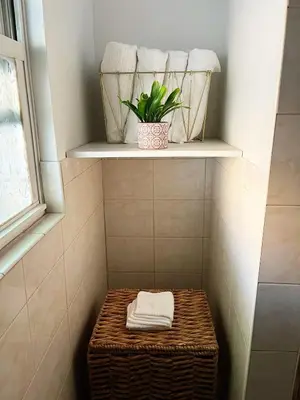 a bathroom with a shelf with towels and a basket at Ironbound 4 bdrm Industrial Suite! FREE parking in Newark