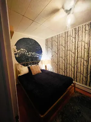 a bedroom with a black bed with a painting on the wall at Ironbound 4 bdrm Industrial Suite! FREE parking in Newark