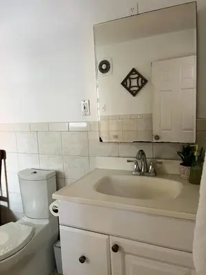 a white bathroom with a sink and a toilet at Ironbound 4 bdrm Industrial Suite! FREE parking in Newark