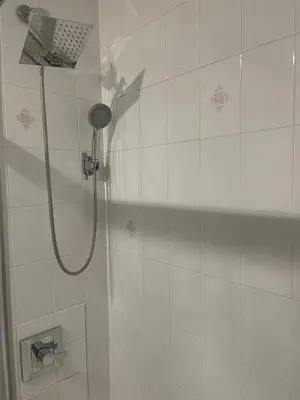 a shower with a shower head in a bathroom at 3br 3bath Duplex NY 23 mins in Hoboken