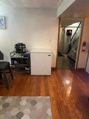 a small white refrigerator in a room with a hallway at Your Home away from Home ! in Baychester