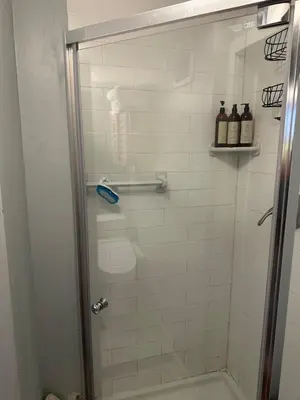 a shower with a glass door in a bathroom at Your Home away from Home ! in Baychester