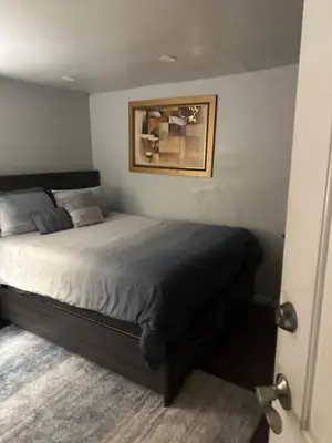 a bedroom with a bed with a picture on the wall at Your Home away from Home ! in Baychester