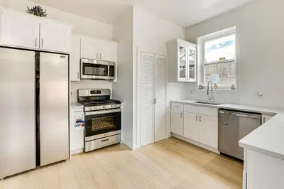 a kitchen with white cabinets and a stainless steel refrigerator at 1 Mi to Prudential Center Remote Work-Ready Apt in Newark