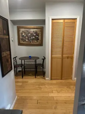 a dining room with a table and a wooden door at Your Home away from Home ! UNIT 2- 1st floor in Baychester