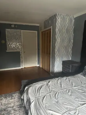 an empty bedroom with a bed and a door at Your Home away from Home ! UNIT 2- 1st floor in Baychester