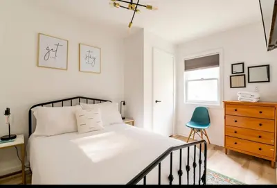 a bedroom with a bed and a blue chair at Modern Pine Tree Chalet with HOT TUB, Outdoor TV, VIEWS, Games & POOL 5 mins away!! in Gilboa