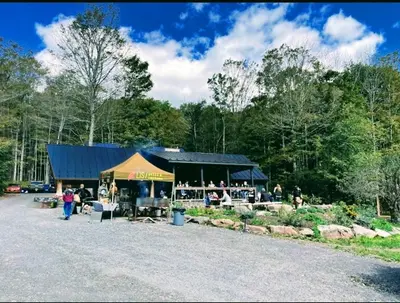 a farmers market with a tent in a parking lot at Modern Pine Tree Chalet with HOT TUB, Outdoor TV, VIEWS, Games & POOL 5 mins away!! in Gilboa
