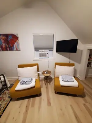 two beds in a living room with a window at Modern Pine Tree Chalet with HOT TUB, Outdoor TV, VIEWS, Games & POOL 5 mins away!! in Gilboa