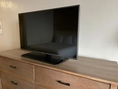 a flat screen tv sitting on top of a dresser at Hilltop Inn & Suites in Yonkers