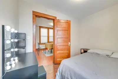 a bedroom with a bed and a table and a door at Walk to Washington Park Remote Work-Ready Apt! in Albany